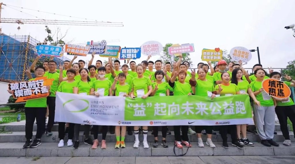 A group of people in lime green t-shirts holding banners