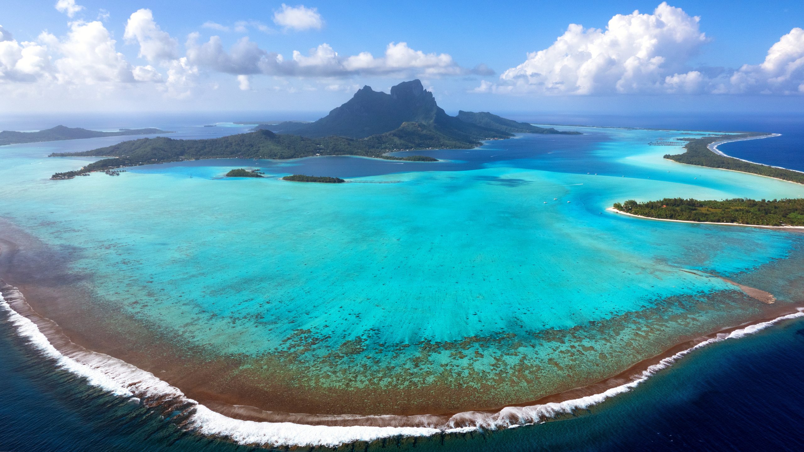 Aerial shot of an island surrounded by turquoise water