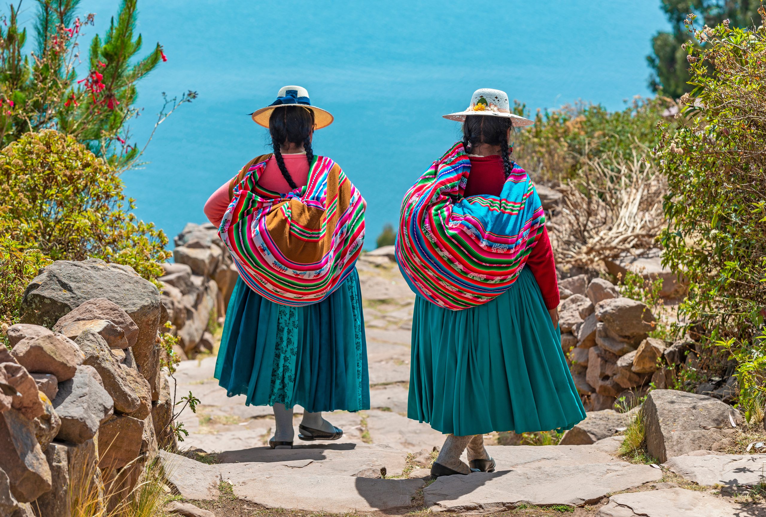 Two woman in bright coloured clothing walking away from the camera